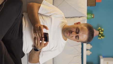 Vertical-video-of-Man-texting-sadly-with-his-girlfriend.
